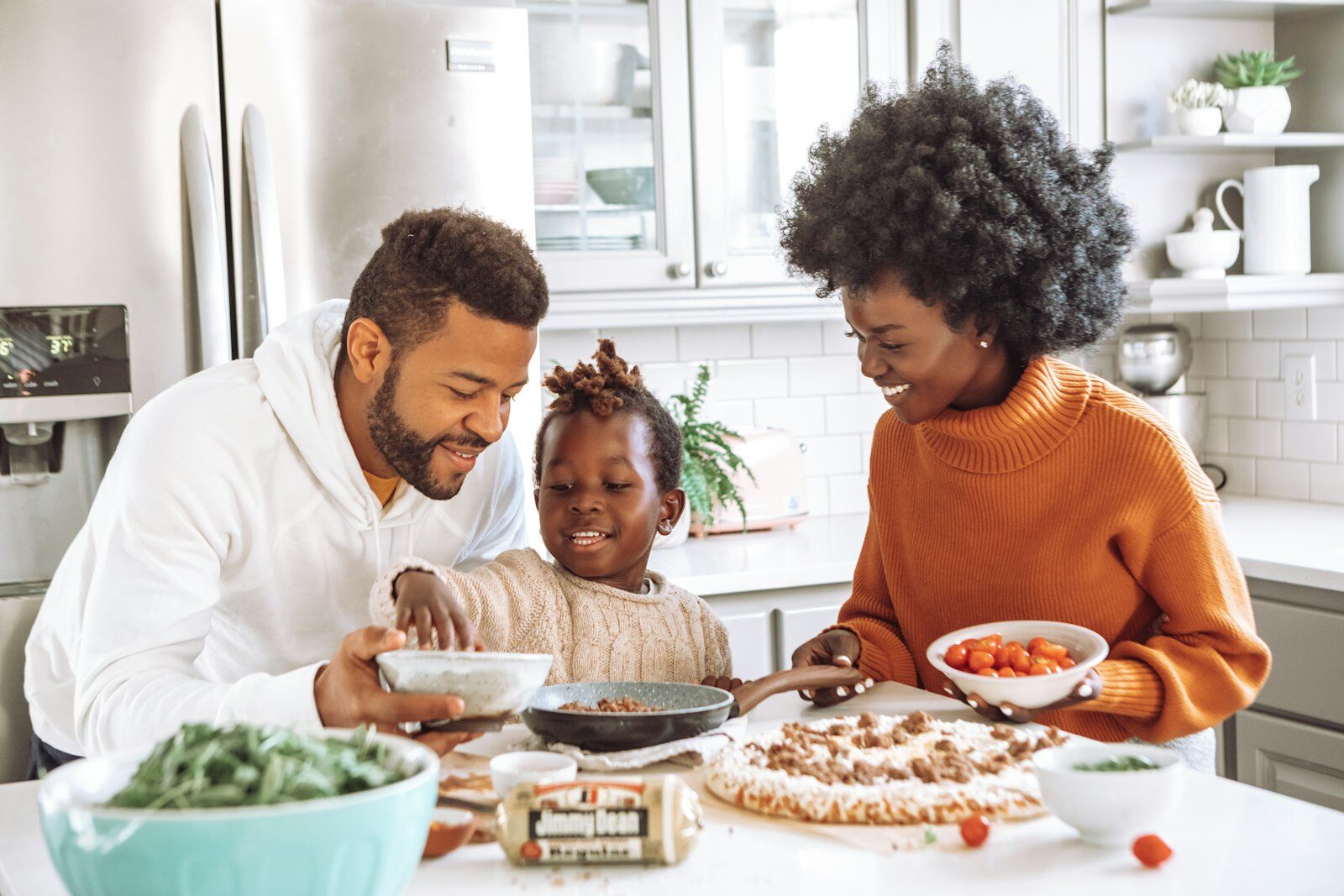 Família preparando comida saudável junta na cozinha